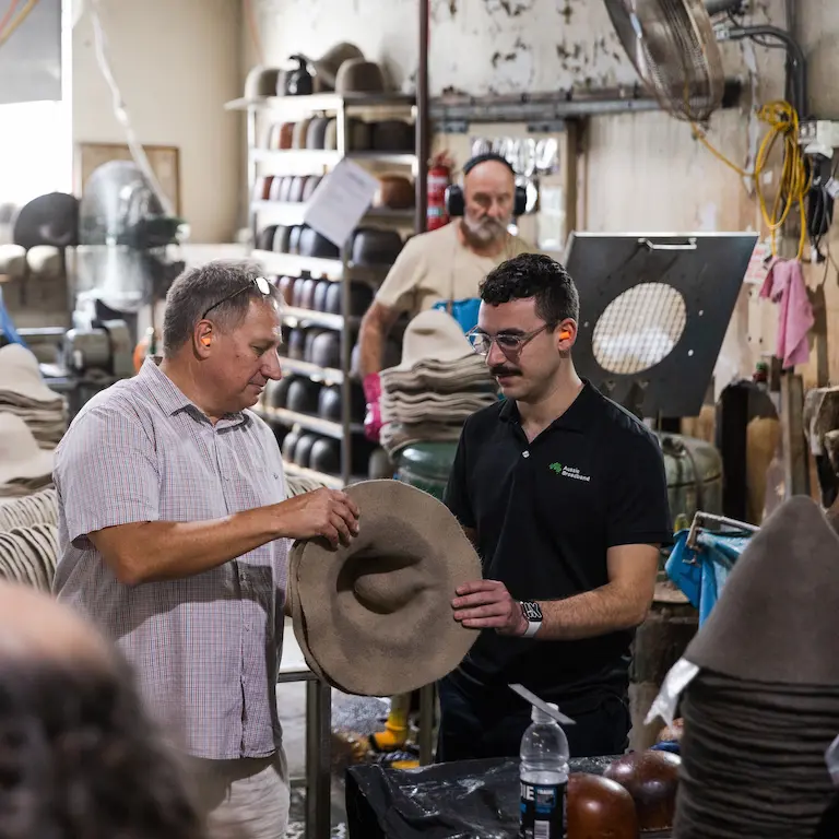 Akubra Operations Manager Ron Palin and an Aussie Broadband staff member looking at a hat in the Akubra factory.