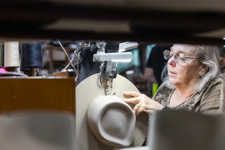 Worker sewing an Akubra hat.